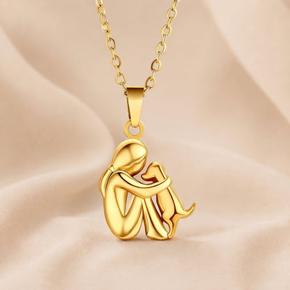 All gold-toned version of the figure-and-dog pendant, glossy, hanging from a matching gold-toned chain 5