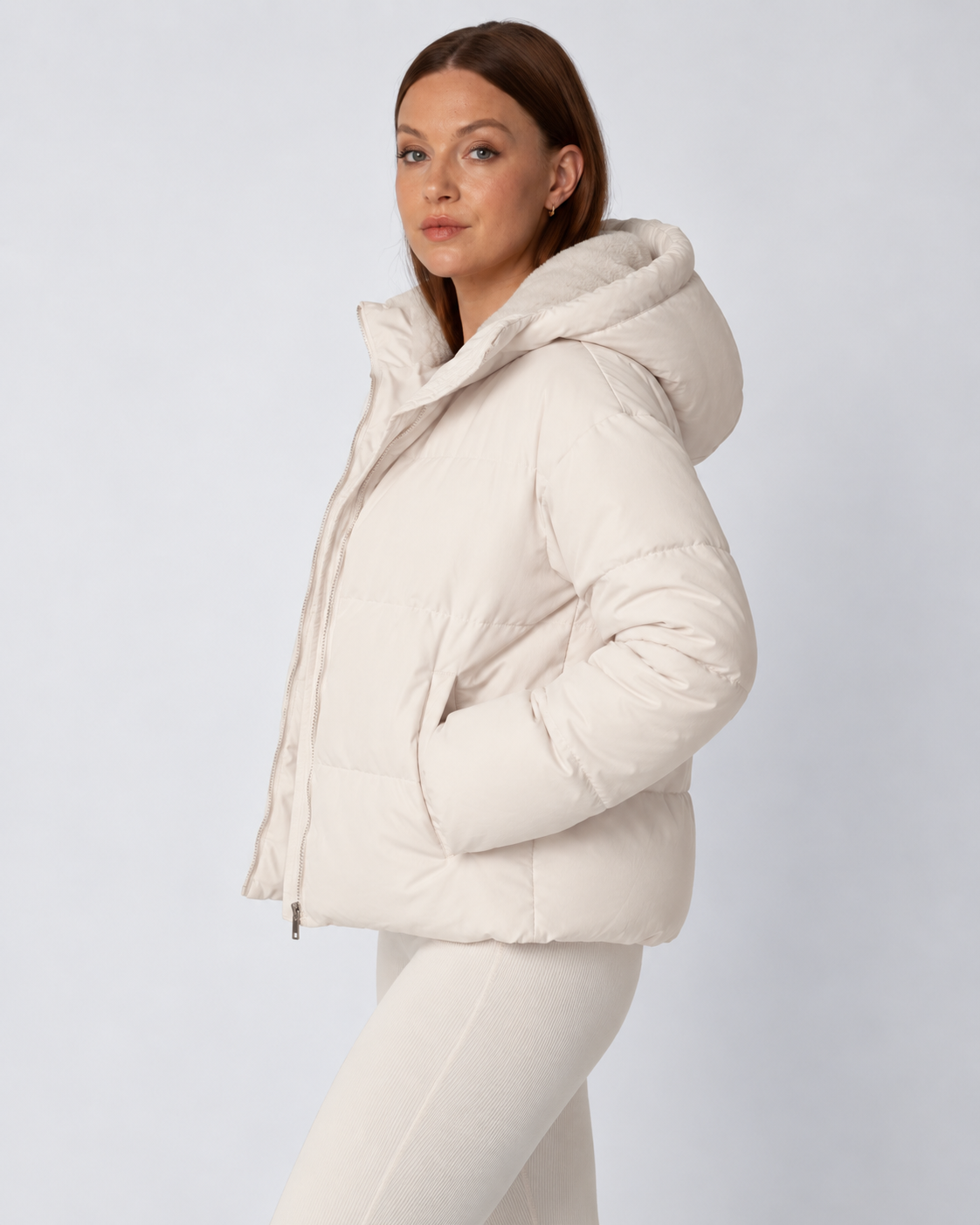 Side view of a cream puffer jacket with the hood up and a hand tucked into the pocket 3