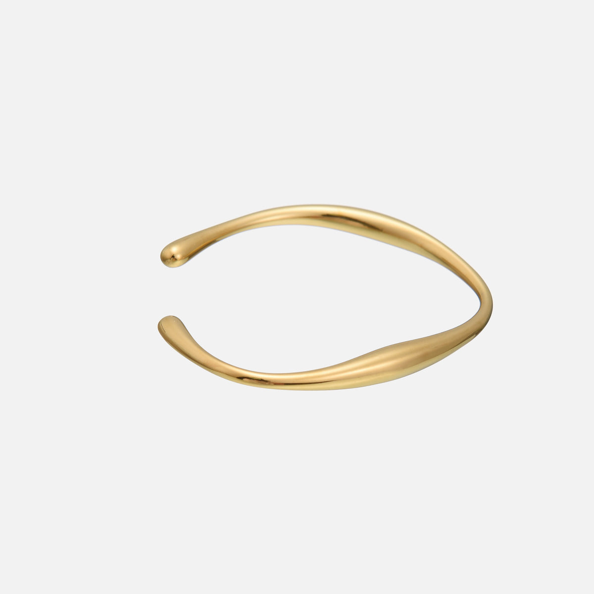 Side view of the open gold-toned cuff, showing its gently curving, organic form and softly tapered teardrop ends against a plain light background. 2
