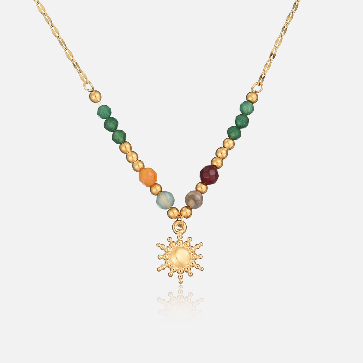 Gold-toned necklace laid flat, front view, with green, orange and plum beads and a dotted sun charm 1