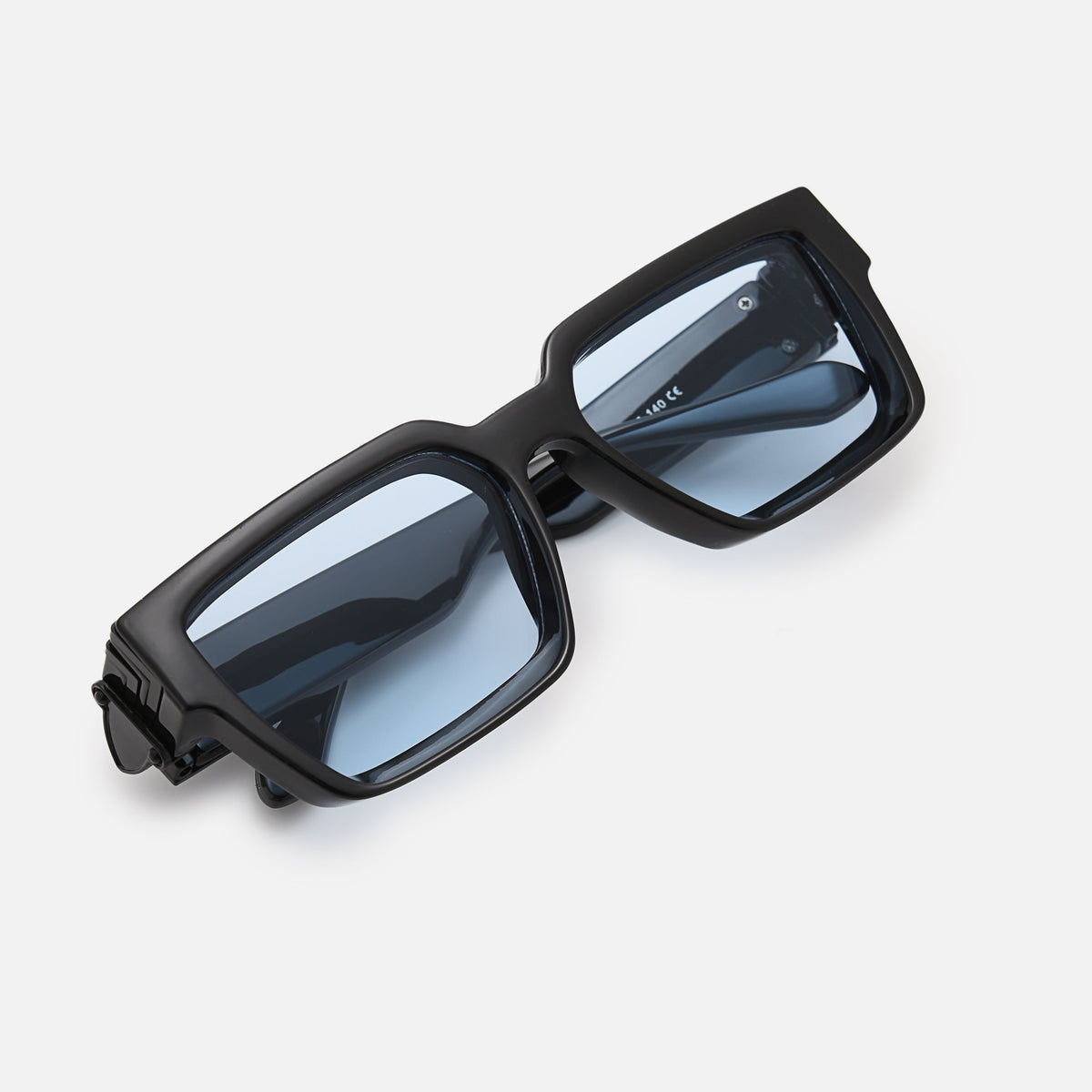Folded black sunglasses with blue-tinted lenses, angled top-down view showing the chunky frame and hinge. 6