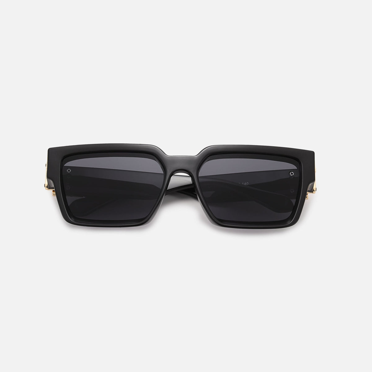 Black square sunglasses with dark lenses and gold-coloured hinge details, folded and laid flat, front view. 9
