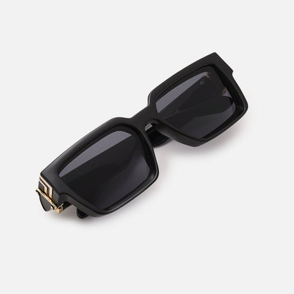 Folded black sunglasses with gold-coloured hinge accents, photographed from above at an angle. 10