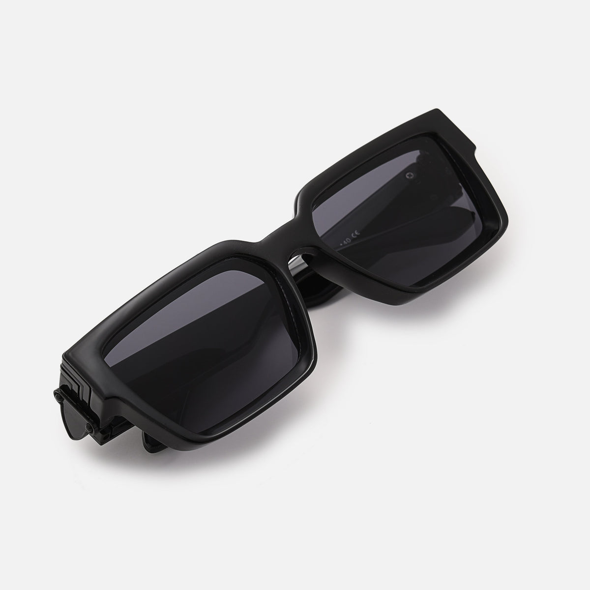 Folded black chunky sunglasses with dark lenses, photographed from above at an angle on a white background. 3