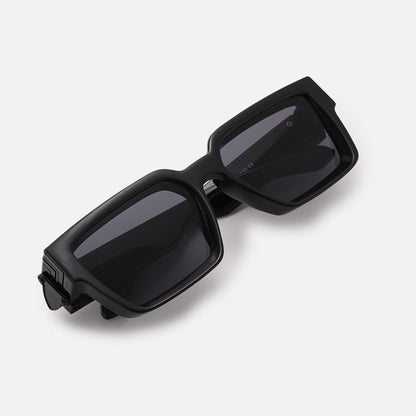 Folded black chunky sunglasses with dark lenses, photographed from above at an angle on a white background. 3