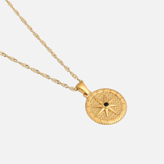 Angled view of the round star pendant and twisted gold chain on a plain light background 2