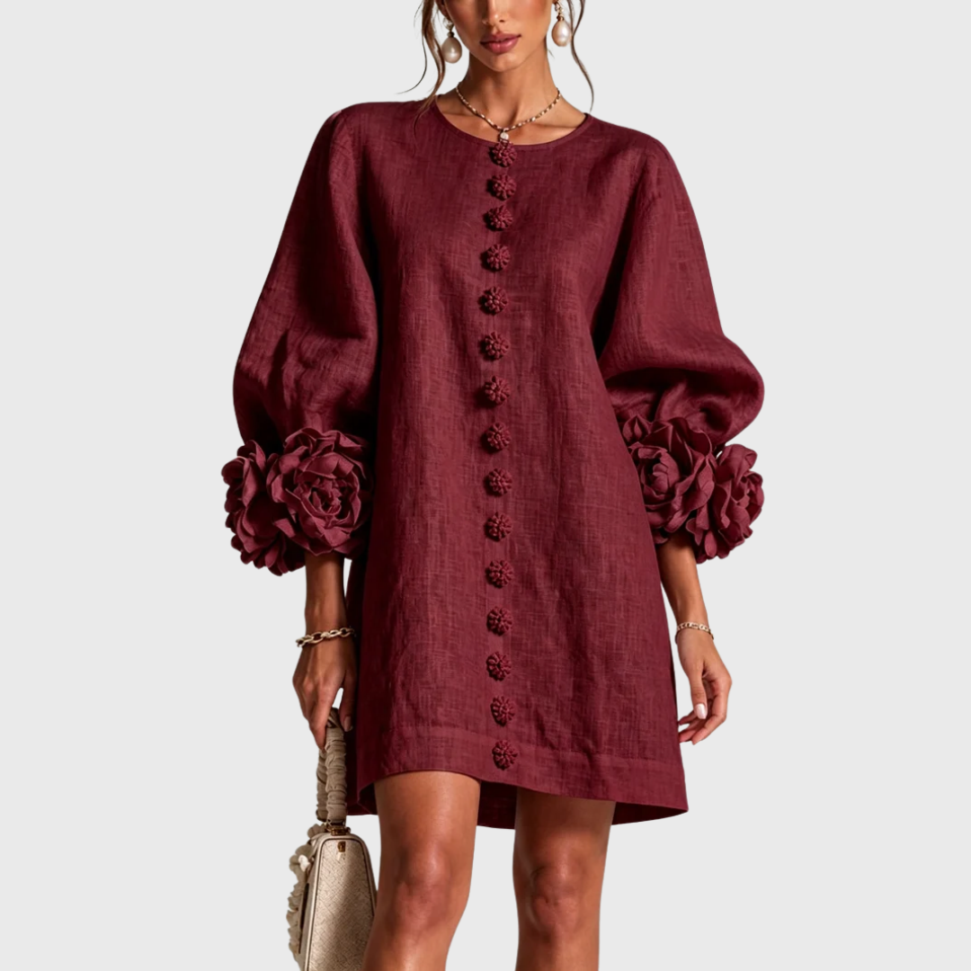 Front view of the dress in deep burgundy on a model, showing the flower buttons and rosette cuffs. 7
