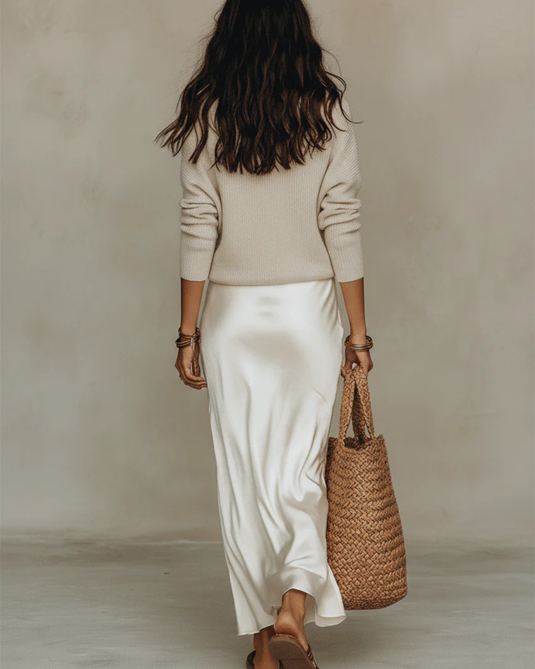 Back view of the cream set, showing the knit sweater and the smooth satin skirt 9
