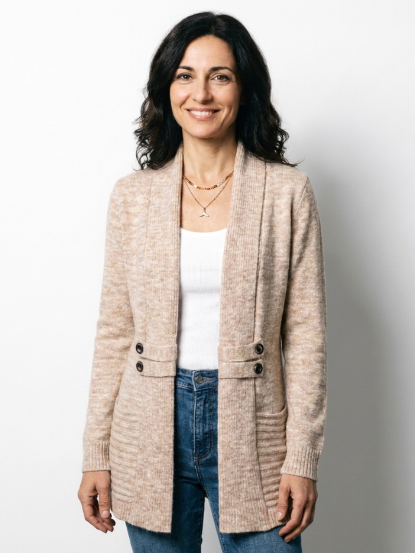 Smiling dark-haired model in the beige cardigan against a plain white backdrop, standing facing the camera 4