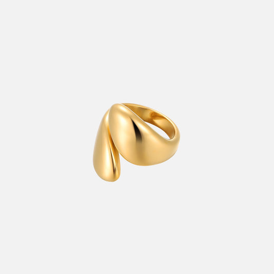 Gold-toned open ring with two smooth, glossy teardrop-shaped ends overlapping, shown at an angle against a plain light grey background. 1