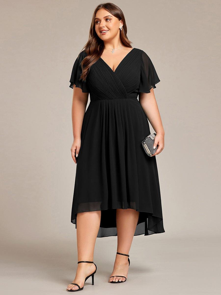 Plus-size model in the black dress holding a small embellished clutch, standing in black strappy heels. 30