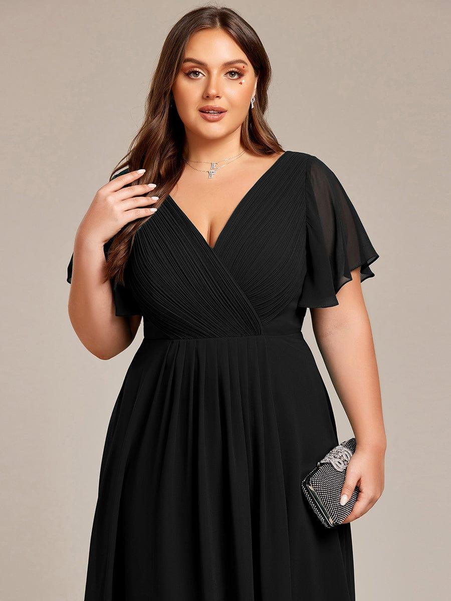 Close-up of the black dress's pleated wrap bodice on a plus-size model holding a sparkly clutch bag. 28