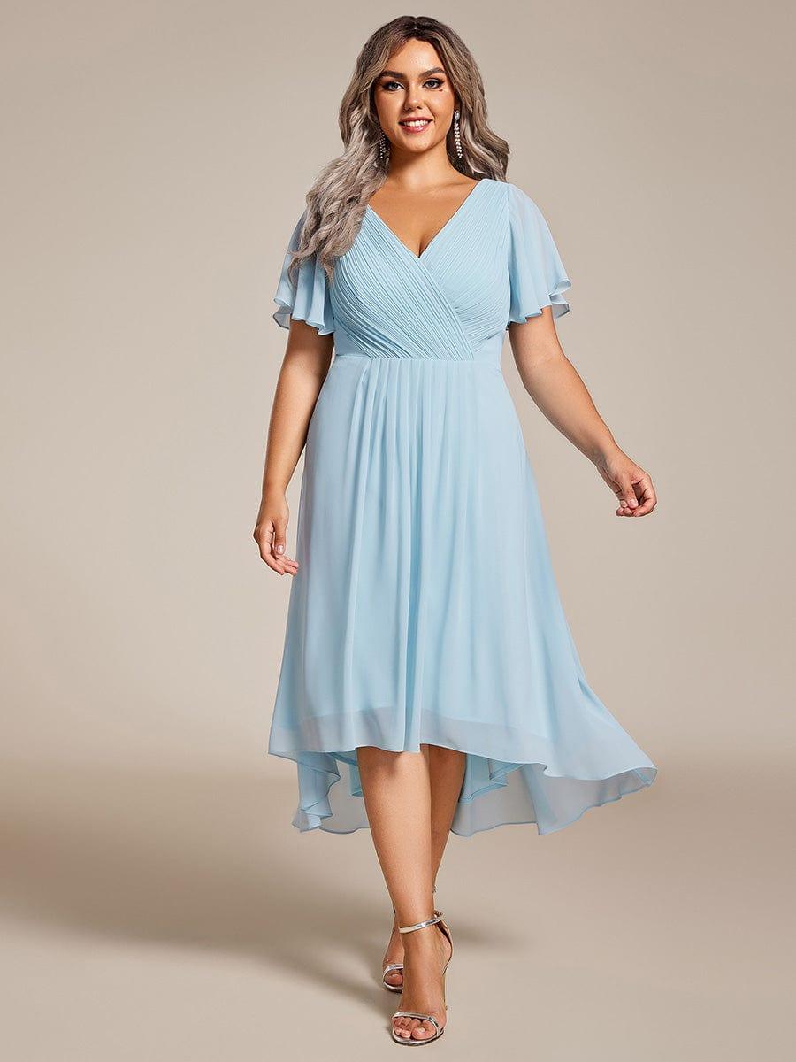 Plus-size model walking in the light blue chiffon dress, front view, with silver heels and long drop earrings. 89