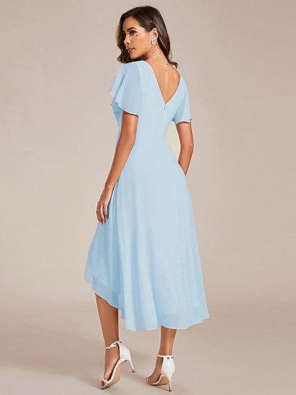 Back view of the light blue dress on a model, showing the V-shaped back, hidden zip and uneven hem. 85