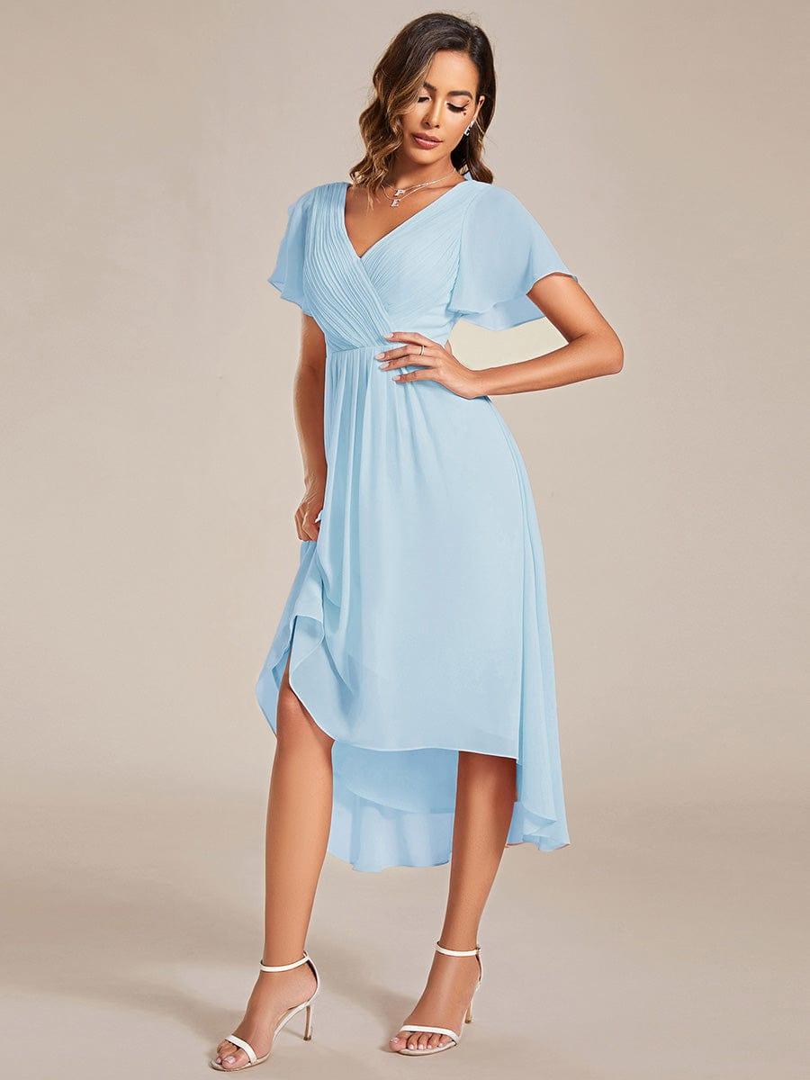 Light blue dress on a model with one hand on her hip, lifting the skirt slightly to show the high-low hem. 88