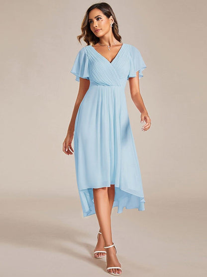 Model wearing the light blue high-low chiffon dress, front view, with white strappy heels and a layered necklace. 84