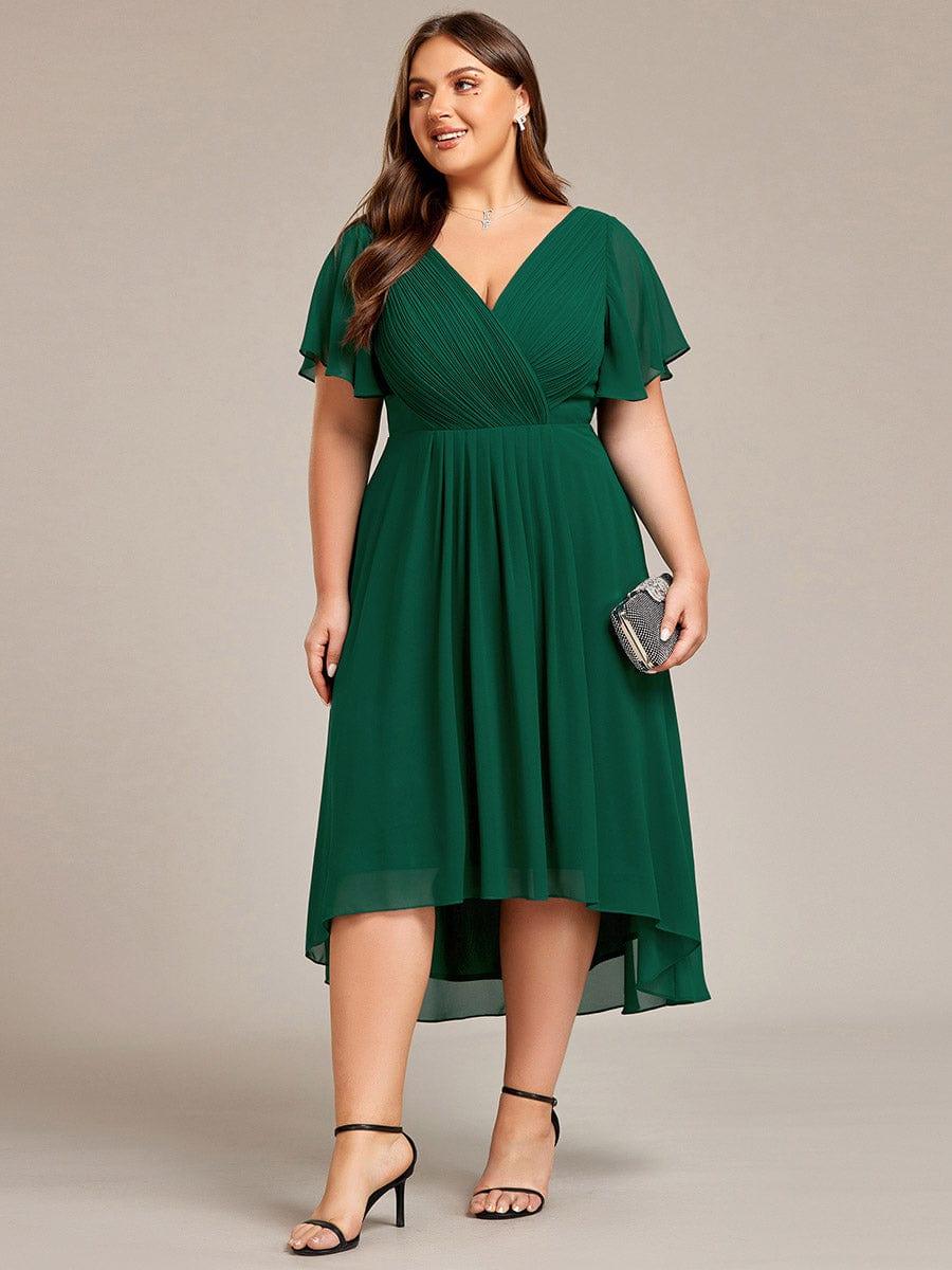 Plus-size model in the deep green dress holding a small embellished clutch, standing in black strappy heels. 40
