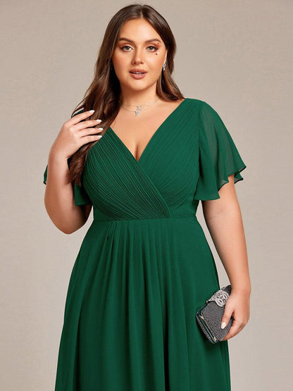 Close-up of the deep green dress's pleated wrap bodice on a plus-size model with a sparkly clutch. 38