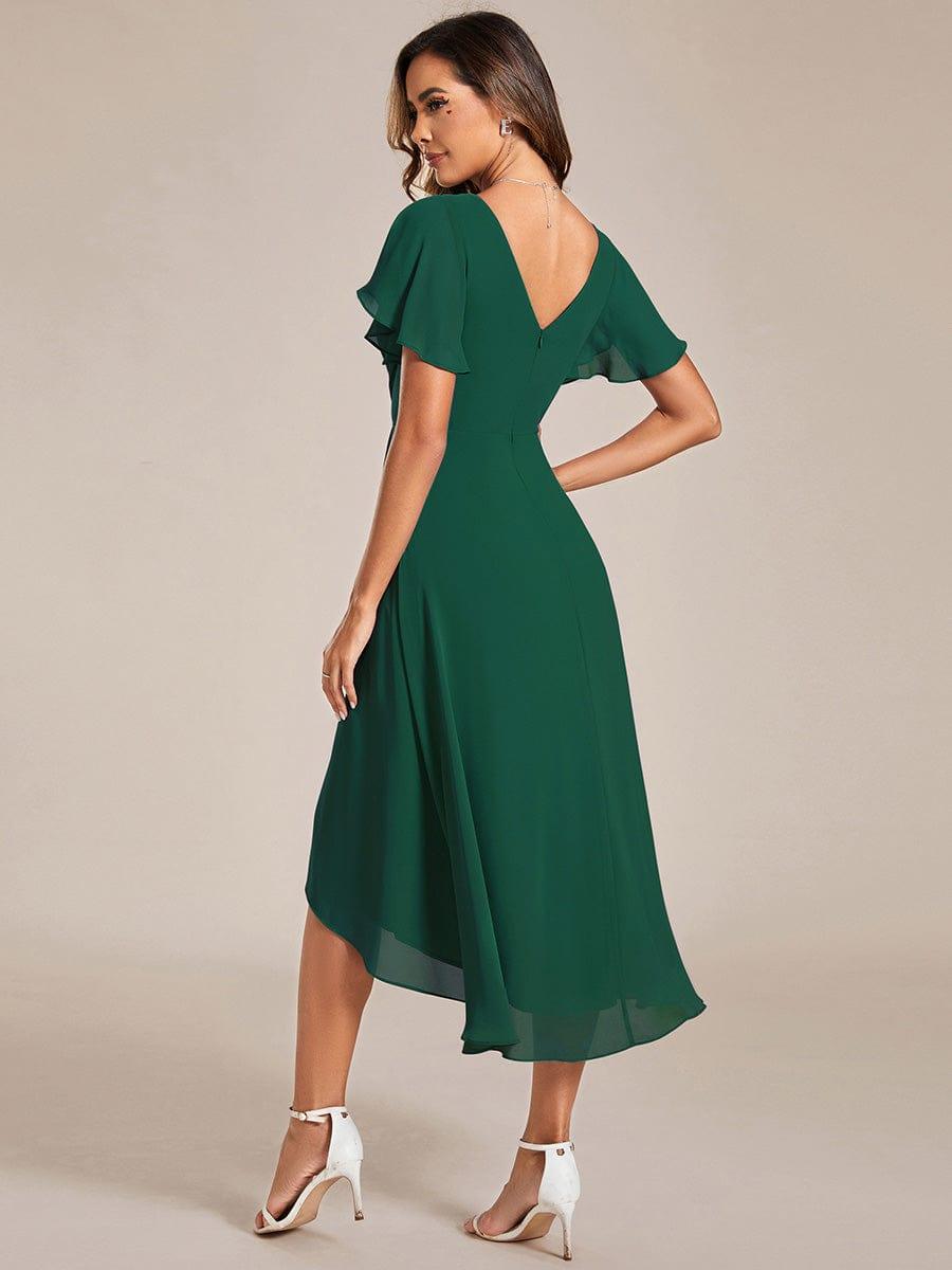Back view of the dark green dress, showing the V-shaped back, zip, flutter sleeves and sweeping high-low hem. 11