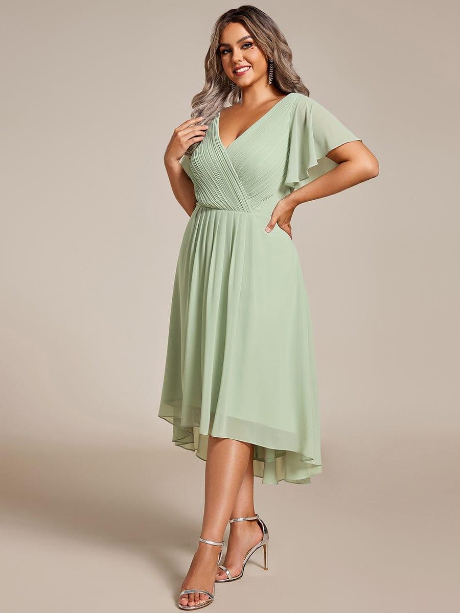Plus-size model in the mint green chiffon dress, three-quarter view, hand on hip, with silver ankle-strap heels. 81