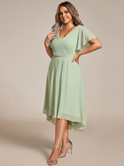 Plus-size model in the mint green chiffon dress, three-quarter view, hand on hip, with silver ankle-strap heels. 81