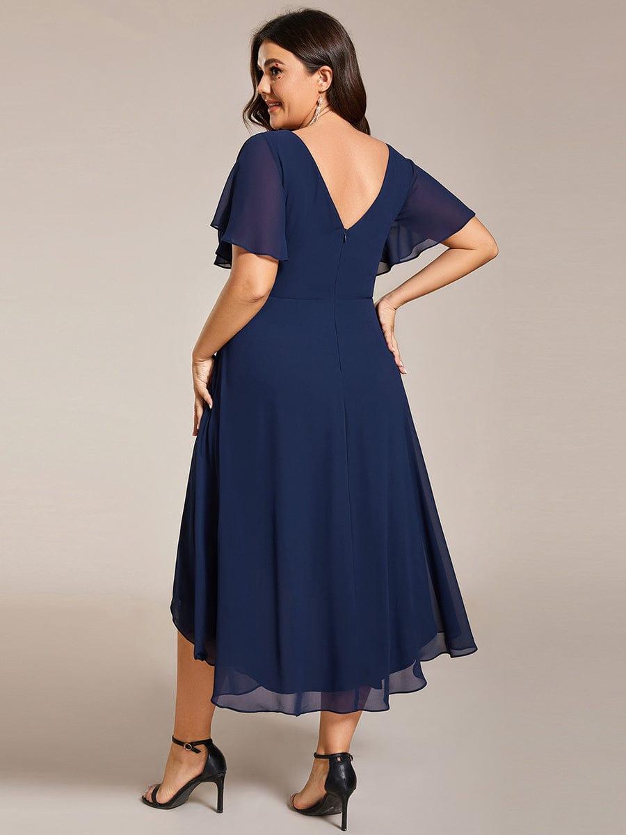 Back view in navy showing the V-shaped back, centre zip and flowing layered high-low chiffon skirt. 56