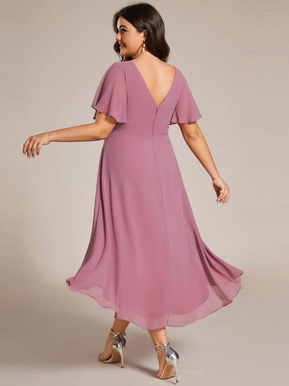 Back view of the dusky pink dress on a plus-size model, showing the V-shaped back and zip. 64