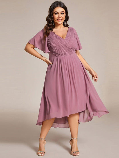Plus-size model in the dusky pink dress with one hand on her hip, showing the flowing high-low skirt. 66