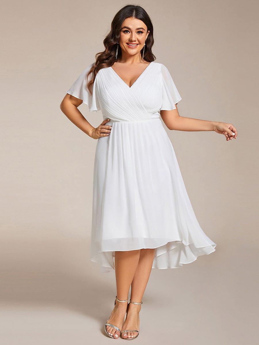 Plus-size model in the white dress with a hand on her hip, front view with high-low hem. 73