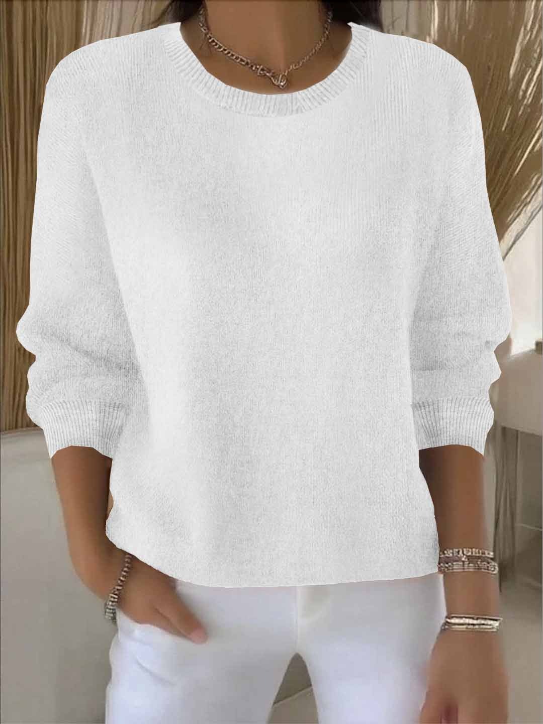 Woman wearing a white round-neck knit jumper with ribbed neckline and cuffs, with white trousers 3