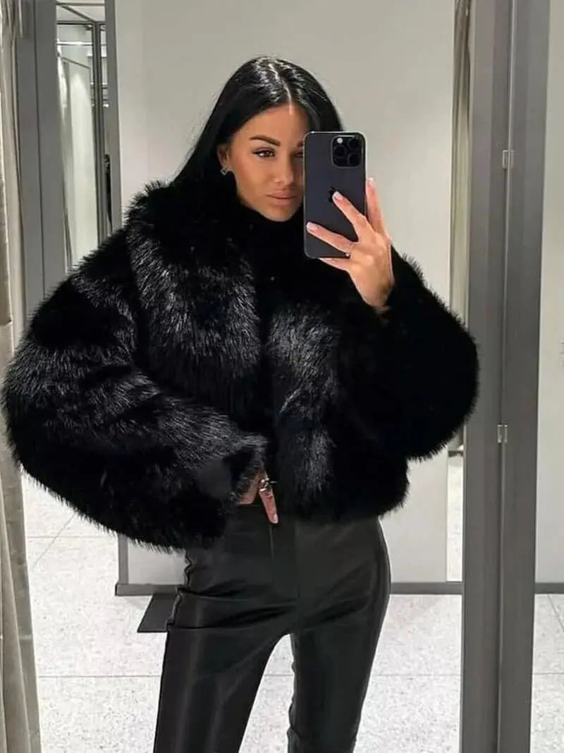 Woman taking a mirror selfie in a black faux fur coat with leather-look trousers 11