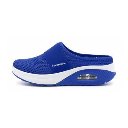 Side view of a single royal blue mesh mule with elastic strap, white midsole and air cushion heel. 11