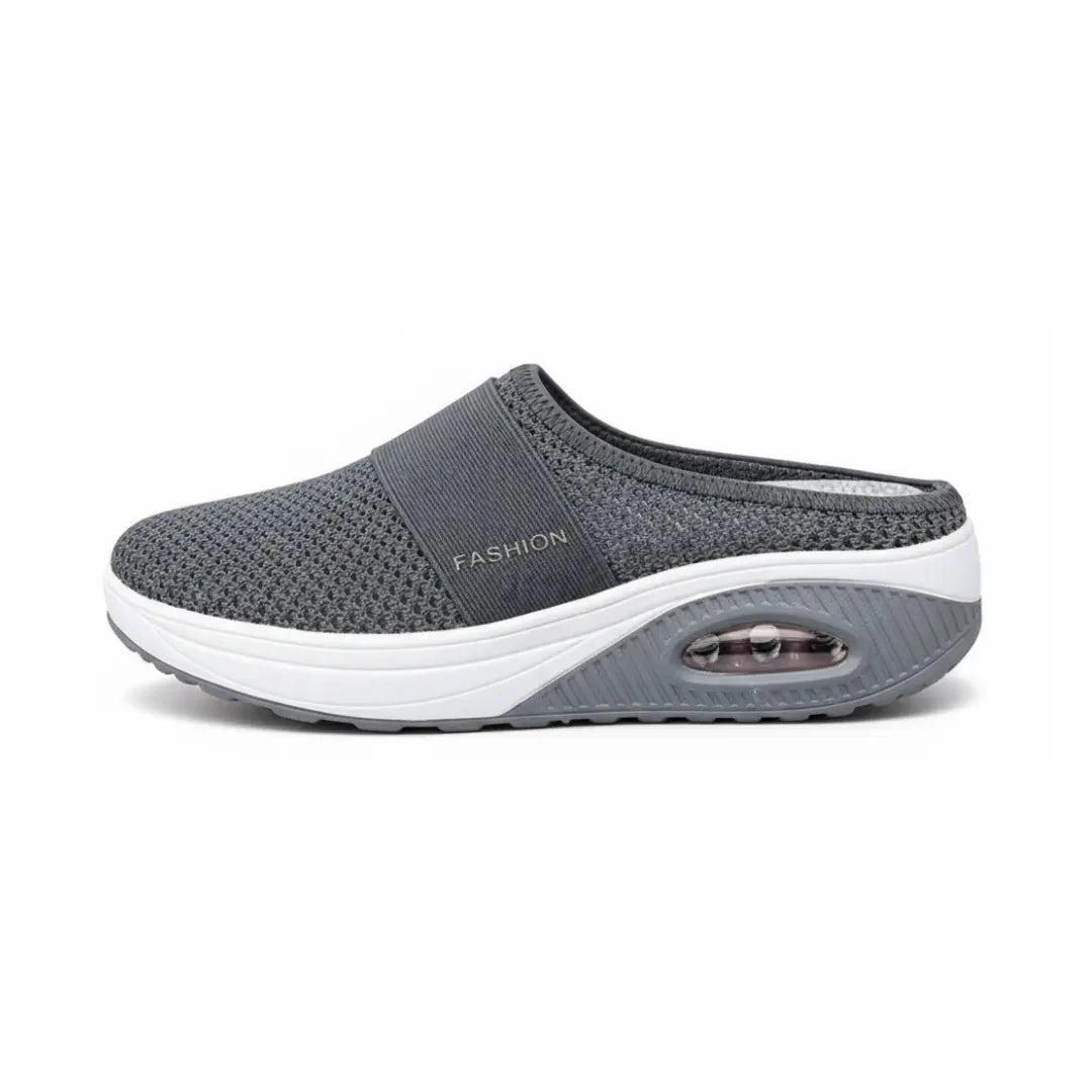 Side view of a single dark grey mesh mule showing the strap, white midsole and air cushion window. 8