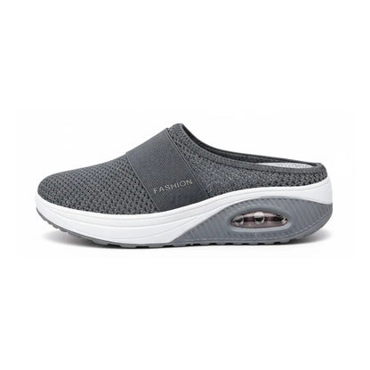Side view of a single dark grey mesh mule showing the strap, white midsole and air cushion window. 8