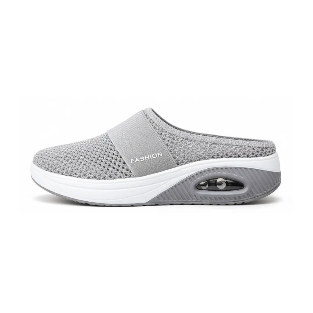 Side view of a single light grey mesh mule with elastic strap and visible air cushion in the sole. 5