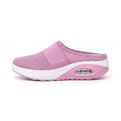 Side view of a single pink mesh mule showing the elastic strap, white midsole and transparent air cushion window. 2