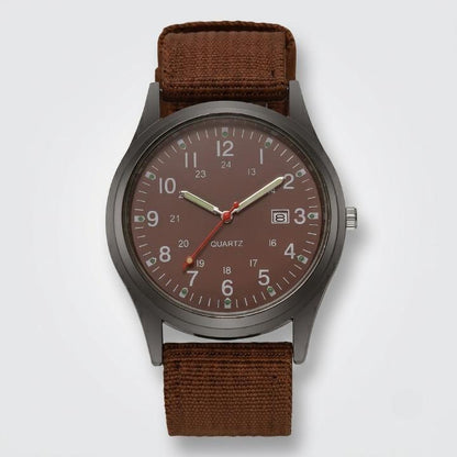 Front view of the watch with a brown dial, luminous hands, date window and brown woven nylon strap on a plain background. 6