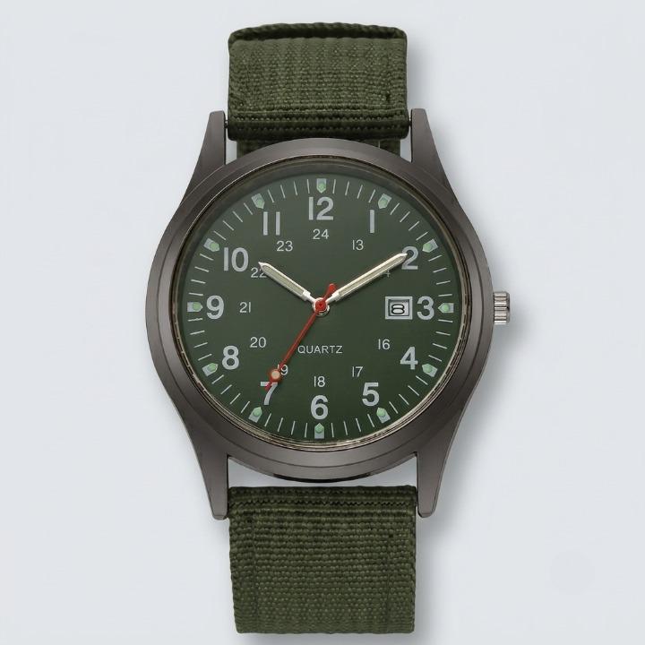 Front view of the watch with a green dial, luminous hands, date window and olive green woven nylon strap on a plain background. 7
