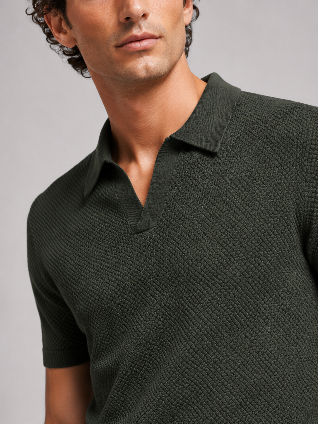 Close-up of dark green knit polo showing the open V collar and woven-look texture 12