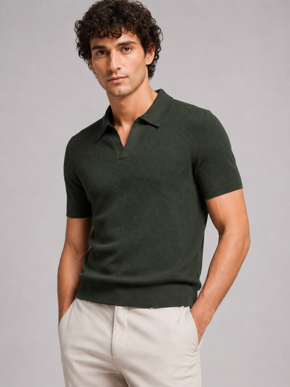 Curly-haired model in dark green textured knit polo with open collar and beige trousers 11