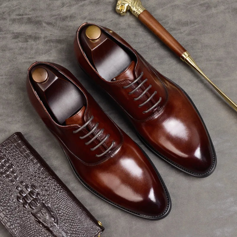 Flat lay of burgundy leather Oxfords with shoe trees, beside a crocodile-embossed wallet and a lion-head shoehorn 4