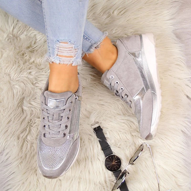 Flat lay from above of grey trainers worn on a fluffy cream rug, with a black wristwatch and sunglasses beside them. 6