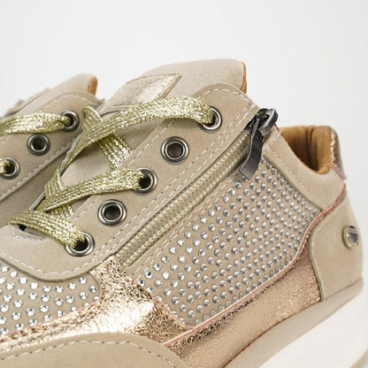 Close-up of beige trainers showing metallic gold laces, metal eyelets, the side zip and rows of small sparkly studs. 8