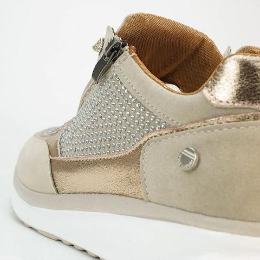 Close-up of the heel and side zip of beige trainers, showing studded panel, metallic gold trim and tan fabric lining. 9
