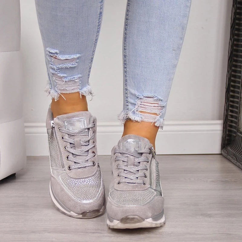 Front view of grey lace-up trainers on a model, showing the sparkly studded toe panel and zips on the outer sides. 5