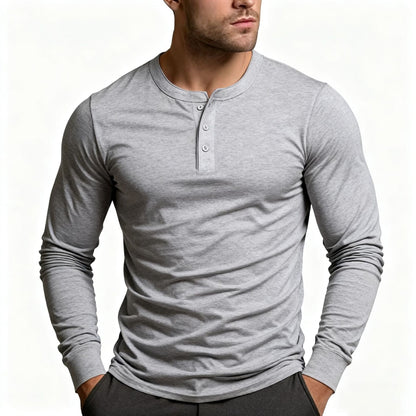 Model wearing the long-sleeve Henley in light heather grey, showing the three-button placket and ribbed cuffs, with dark trousers. 2