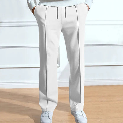 Trousers in white on a model, front view showing the drawstring waist and centre crease lines, worn with white trainers. 4