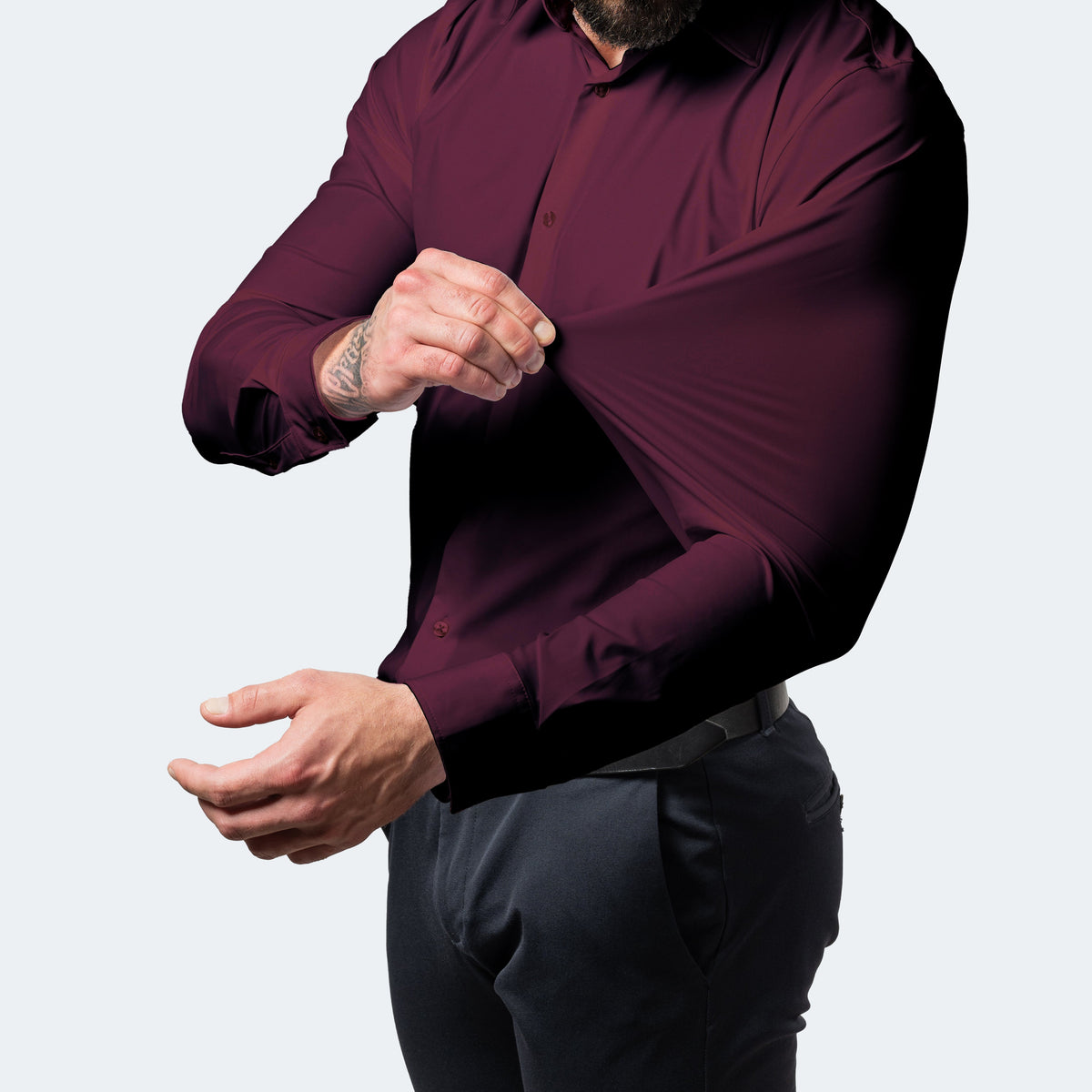 Burgundy shirt on a model pulling the sleeve fabric outwards to demonstrate stretch 10