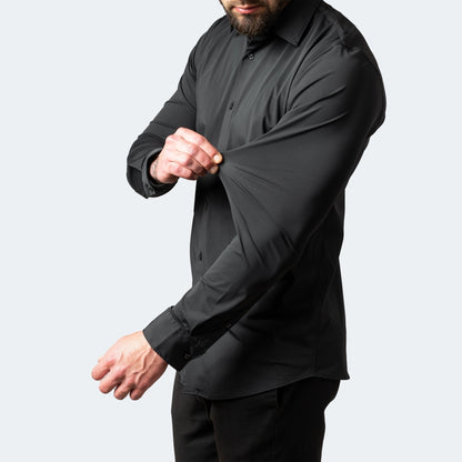 Black buttoned shirt on a model stretching the sleeve fabric away from the arm 6