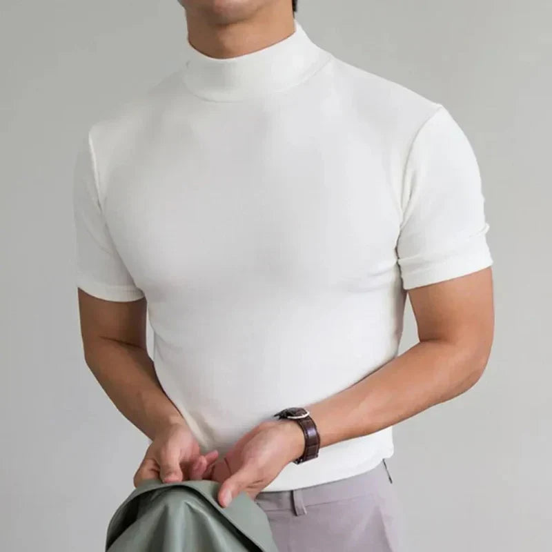 Model wearing the top in white with light trousers, a brown leather-strap watch and a green jacket in hand 4